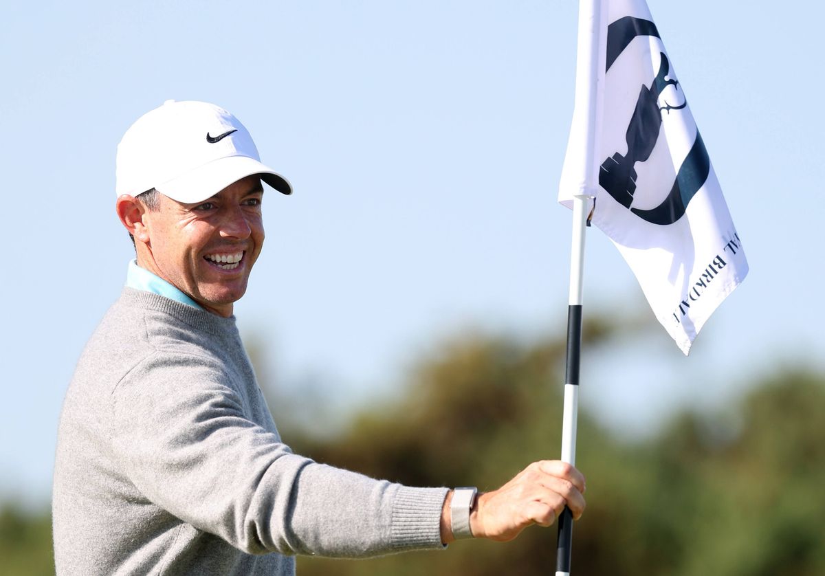 Rory McIlroy holds a flag