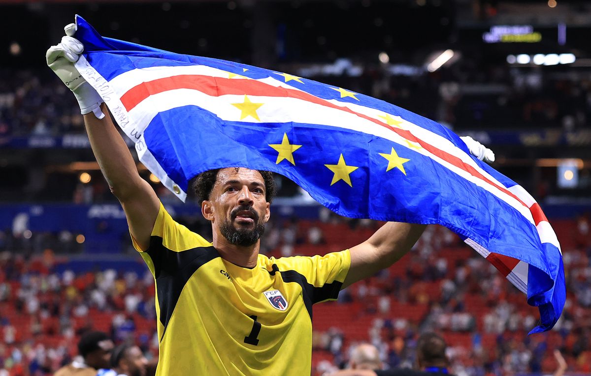 Vozinha holding up a Cape Verde flag