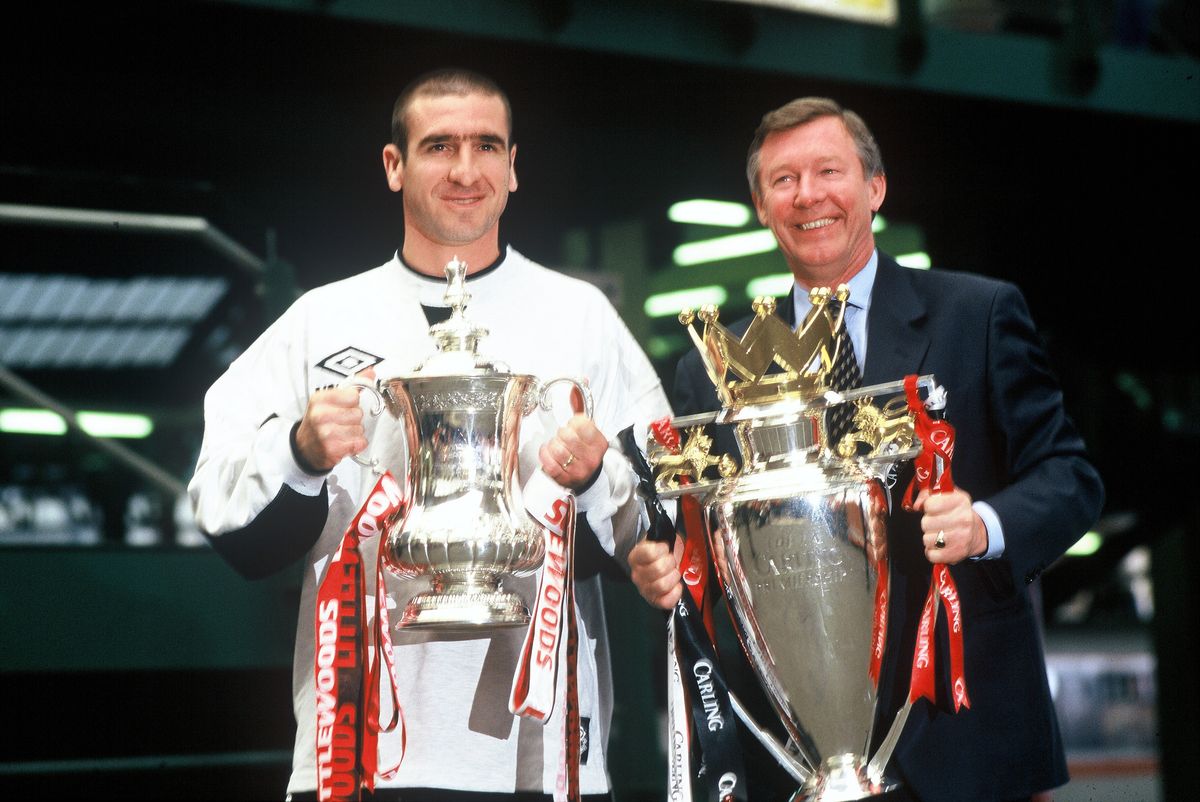 Eric Cantona and manager Sir Alex Ferguson of Manchester United with the FA Cup and Premiership Trophy at Victoria Station, Manchester on May 12, 1996 after completing The Double.