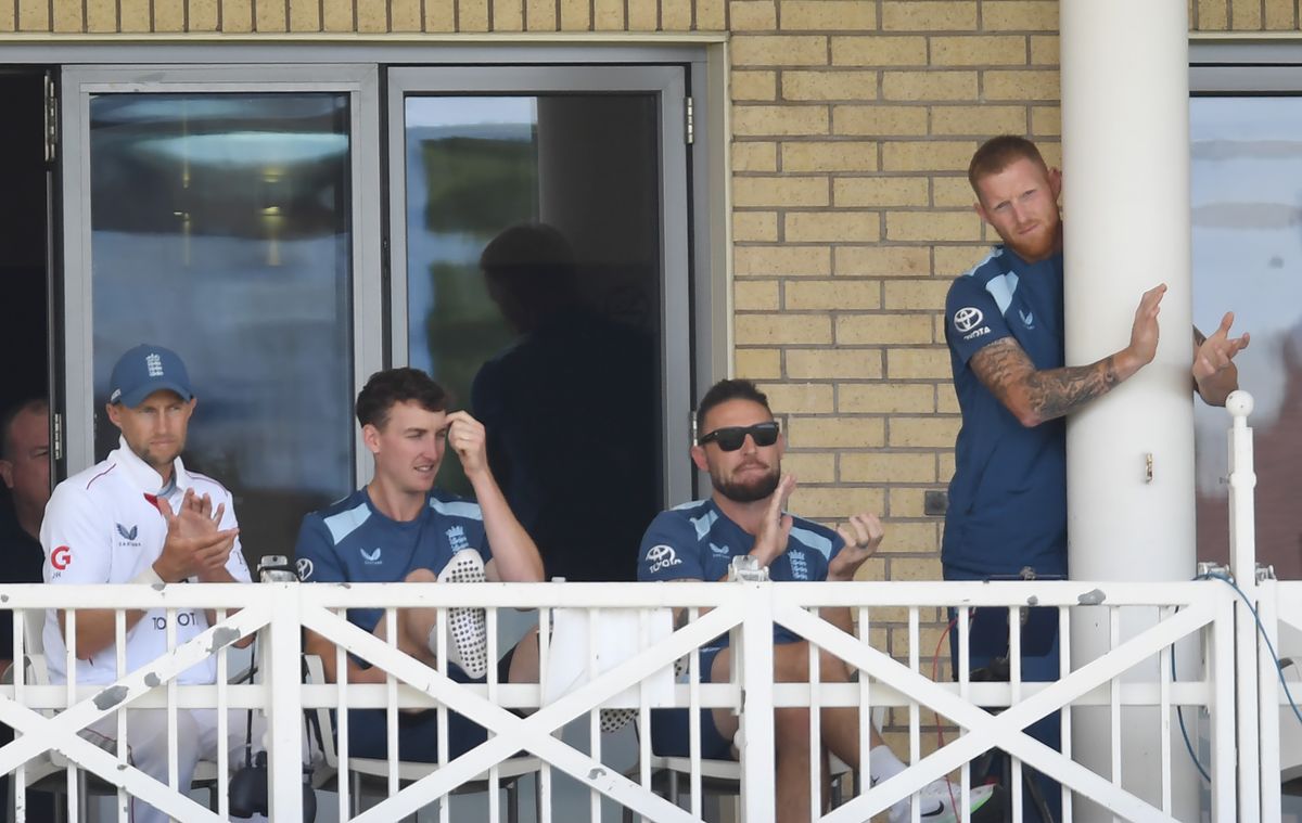 Ben Stokes (R), Brendon McCullum, Harry Brook and Joe Root (L) of England watch from the dressing room balcony