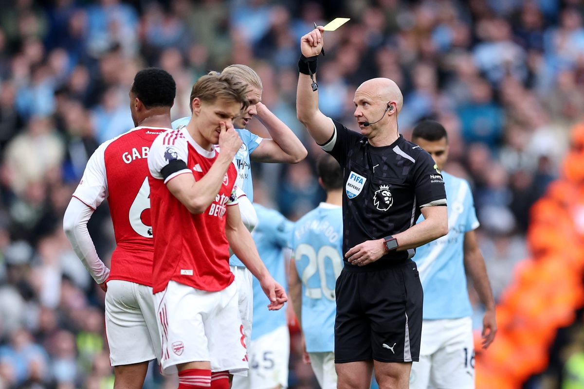MANCHESTER, ENGLAND - APRIL 19: Referee Anthony Taylor shows a yellow card to Erling Haaland of Manchester City and Gabriel of Arsenal during the Premier League match between Manchester City and Arsenal at Etihad Stadium on April 19, 2026 in Manchester, England. (Photo by Michael Regan/Getty Images)