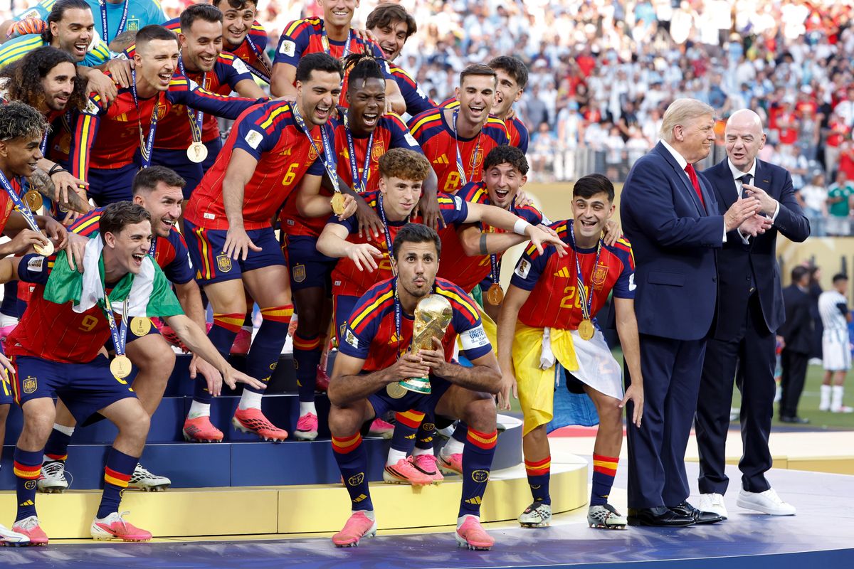 Rodri #16 of Spain lifts the trophy while US President Donald Trump and FIFA President Gianni Infantino look on