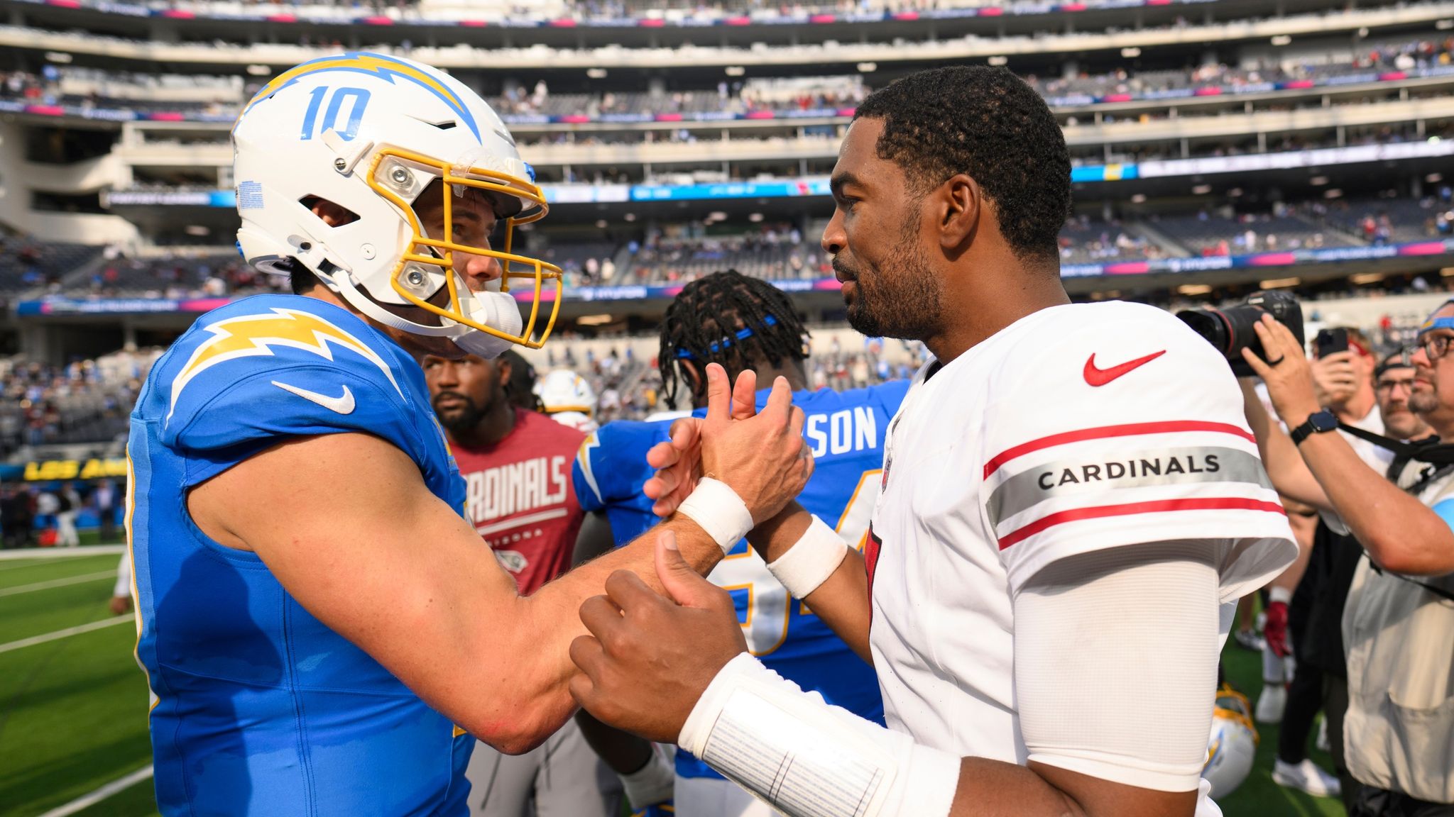 Chargers quarterback Justin Herbert shakes hands with Cardinals quarterback Jacoby Brissett