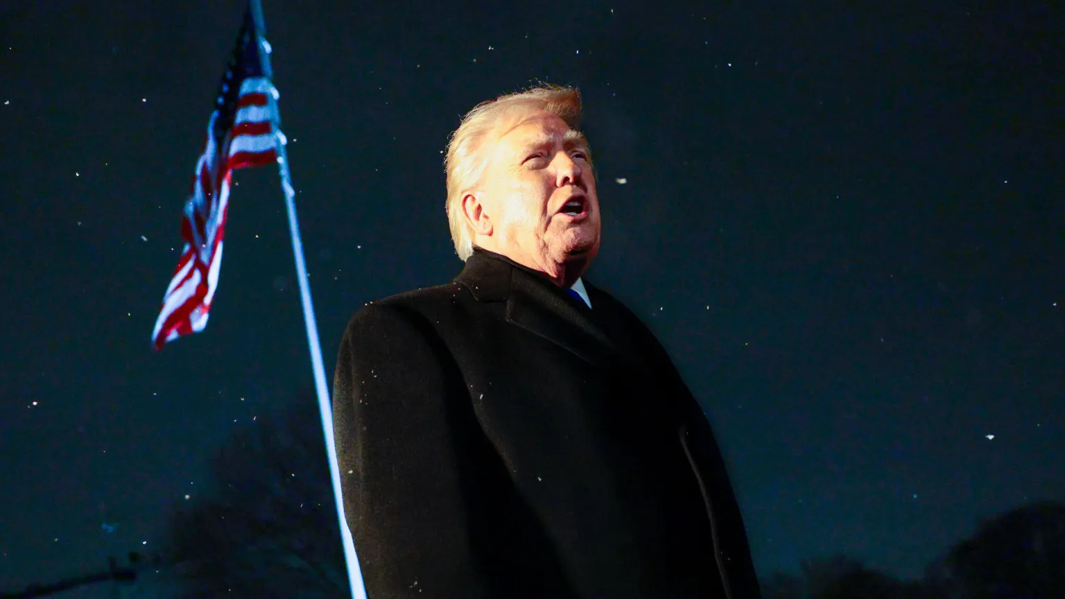 EPA US President Donald Trump responds to a question from the news media as he walks to board Marine One on the South Lawn of the White House. An American flag is visible behind him.