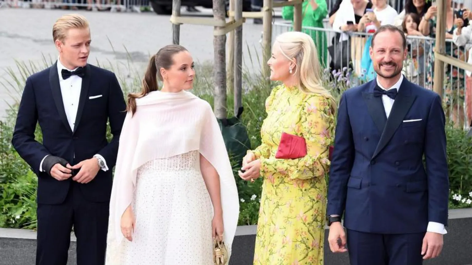 Rune Hellestad/ Four people in smart clothes with men in bow ties on the outside and two women in white and yellow in the centre