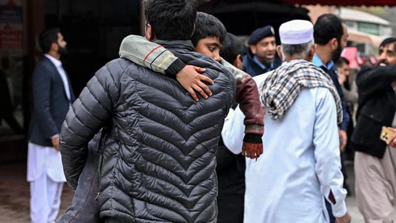 AFP via A man carries an injured boy to a hospital following an explosion at a mosque in Islamabad on February 6, 2026