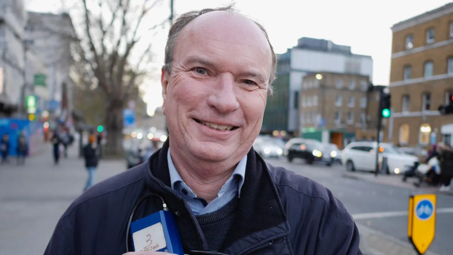 Tom Bonnett Prof Jonathan Grigg, eyes to camera, stands next to busy main road