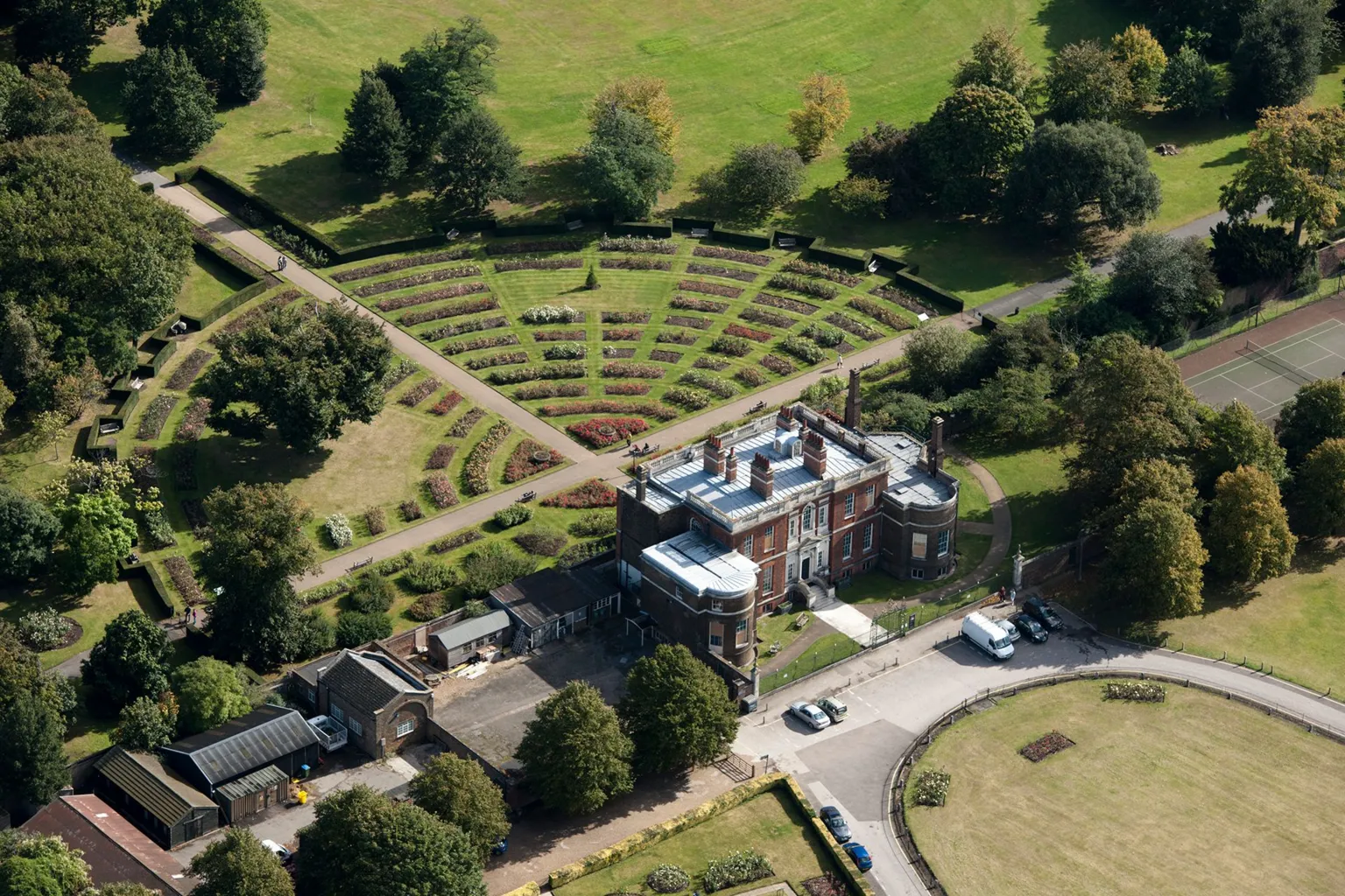English Heritage/ An aerial shot of Georgian mansion on the edge of Greenwich Park, showing lawns and a car park