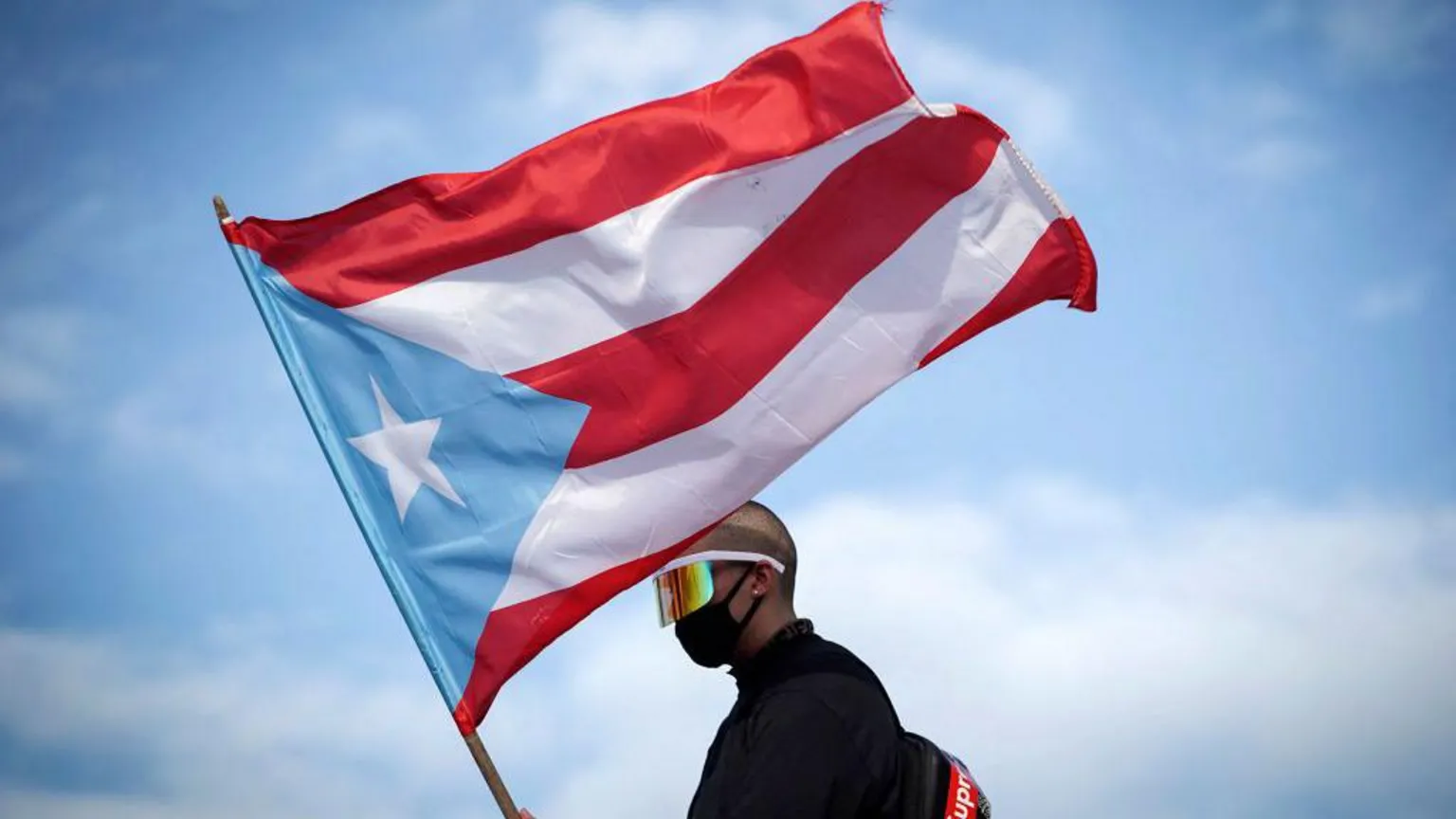  Puerto Rican reggaeton singer Bad Bunny waves a Puerto Rican flag as he takes part of a demonstration demanding Governor Ricardo Rossello's resignation in San Juan, Puerto Rico on July 17, 2019.