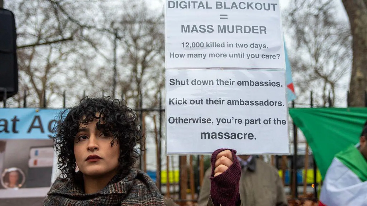 LightRocket via a woman with curly hair holds up a sign that reads 