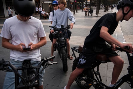 Schoolboys cruise on e-bikes at Manly Beach on Sydney’s Northern Beaches.