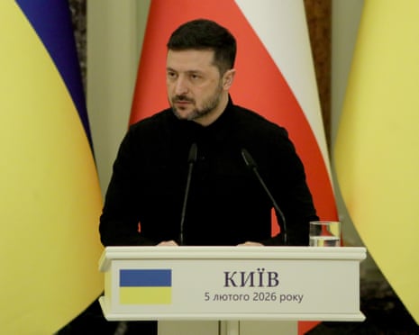 Volodymyr Zelenskyy stands at a lectern with Ukrainian and Polish flags behind him