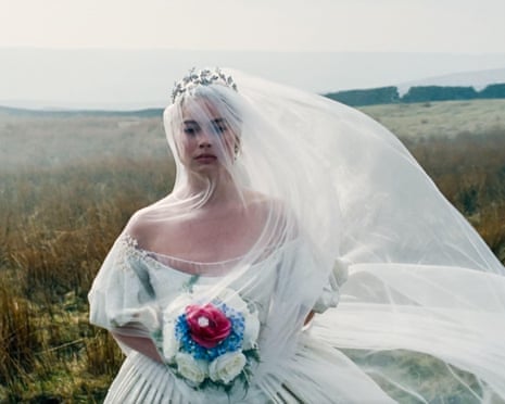 Actor Margot Robbie standing on the Yorkshire moors in a bridal dress, and holding a small bouquet of flowers, while filming her new movie Wuthering Heights.