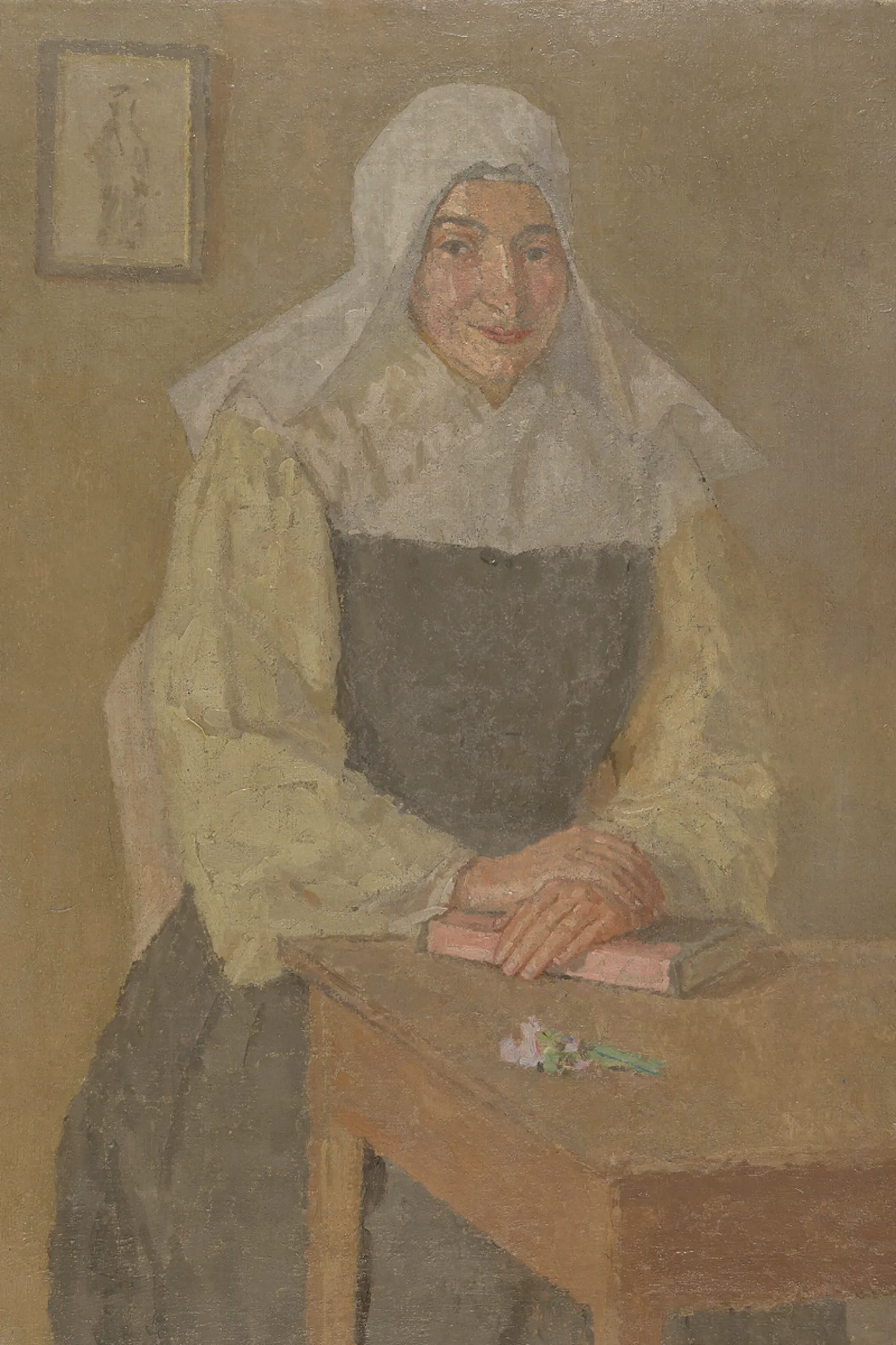 Museum Wales Oil painting of a nun seated at a table with her hands crossed over a book lying on it. She wears a white veil, a cream coloured blouse and a black pinafore style long dress. She is smiling slightly to the left of the painting. There is a picture of a figure on a wall behind her.
