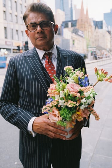 a man in a suit holding a bunch of flowers