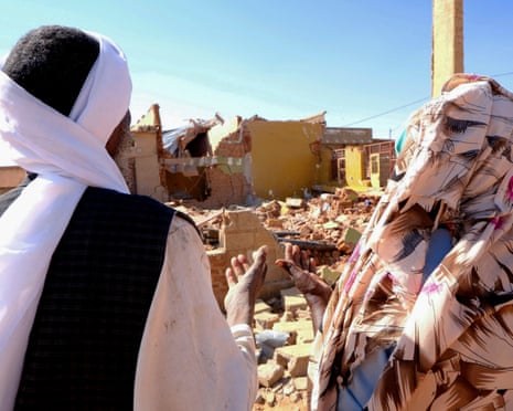 People pray in front of the rubble of a house levelled by a drone strike