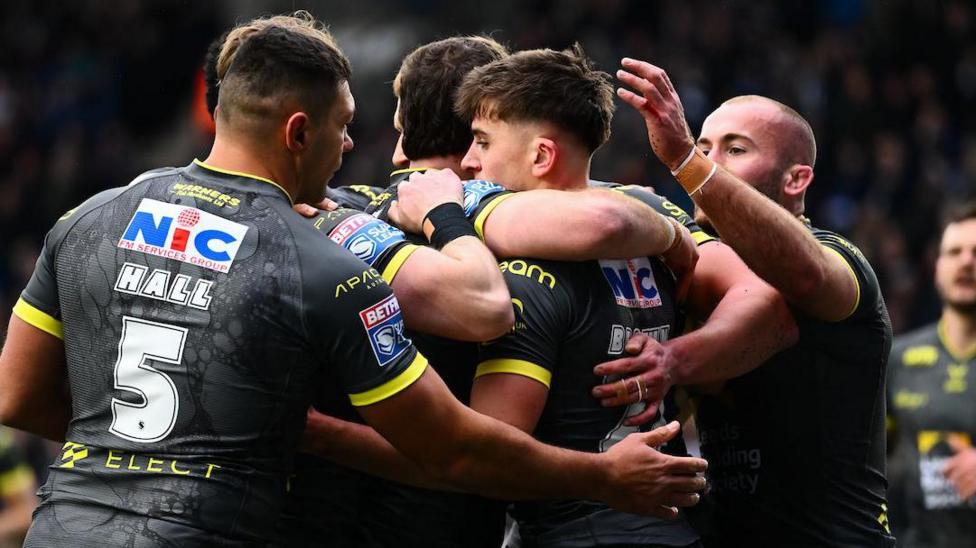 Leeds Rhinos player George Brown is congratulated by team-mates after scoring a try against Widnes Vikings.