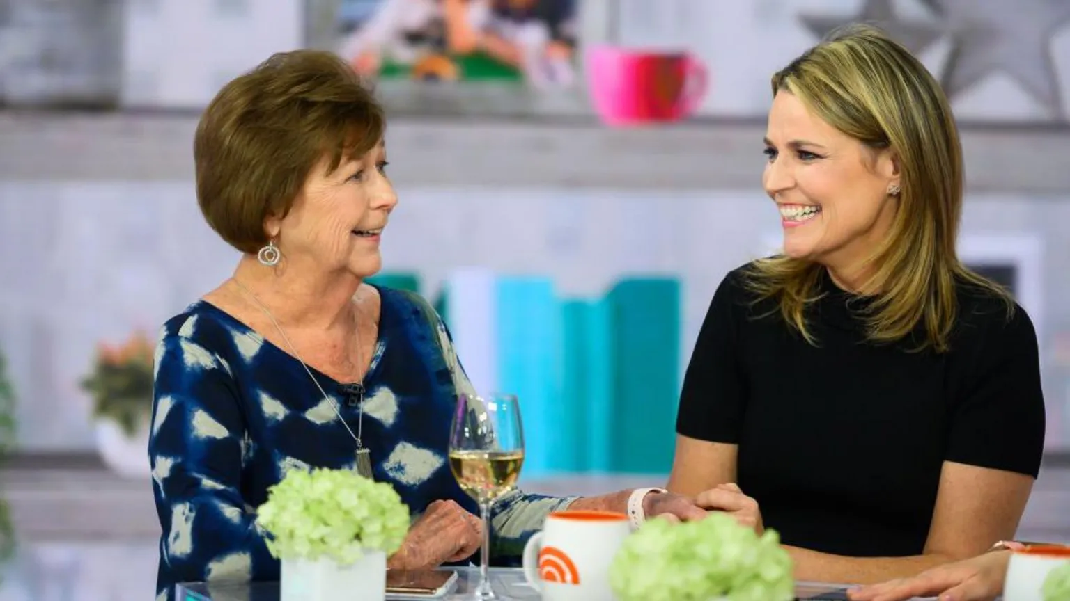  Savannah Guthrie (right) and her mother Nancy Guthrie (left) sit together at a table on the set of the TODAY Show.