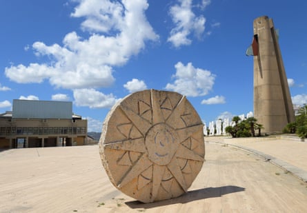Sun sculpture and concrete tower in a town in Sicily