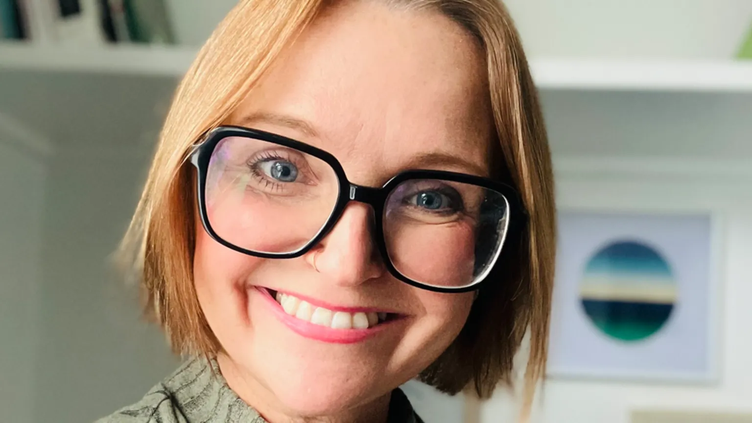 Dr Jenny Kidd A woman with glasses smiling at the camera. It is a head shot of her.