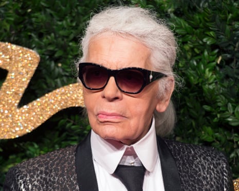Lagerfeld in a sparkly jacket, tie and dark glasses