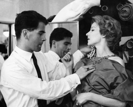 A young Lagerfeld dresses a model backstage at a show