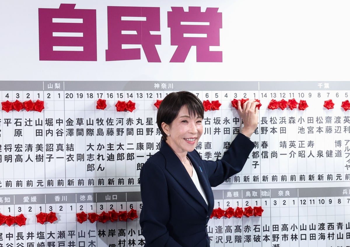 Japan's prime minister Sanae Takaichi placing a red paper rose on the name of an elected candidate at the LDP headquarters last night.