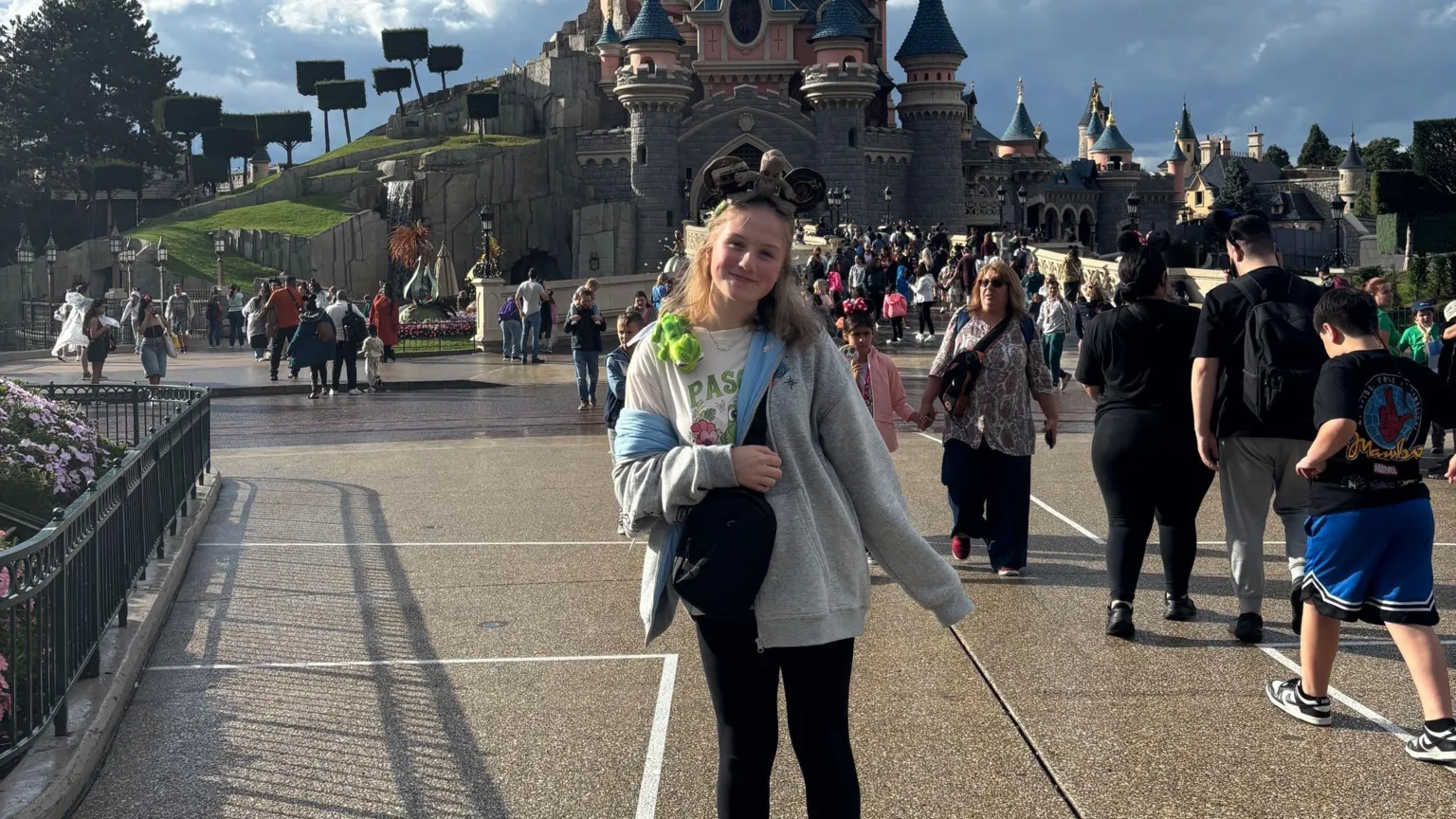 Supplied by Milly Milly is pictured standing in front of the famous princess castle at Disneyland paris. She is wearing Mickey Mouse ears and Disney-themed shoes. 
