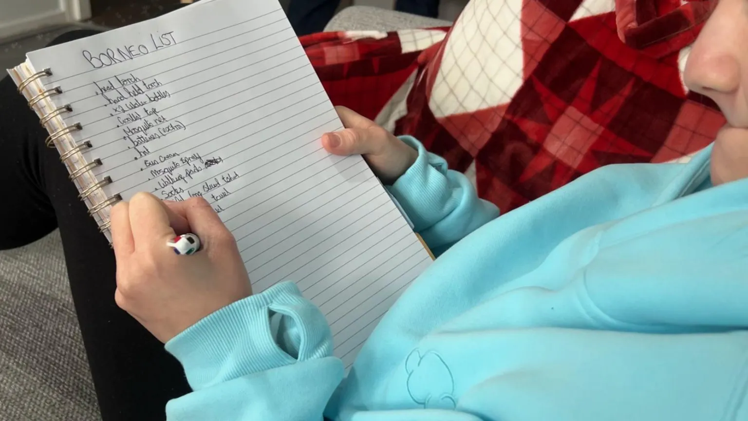Milly is pictured writing a list of all the things she needs to take with her, including mosquito spray and a head torch.