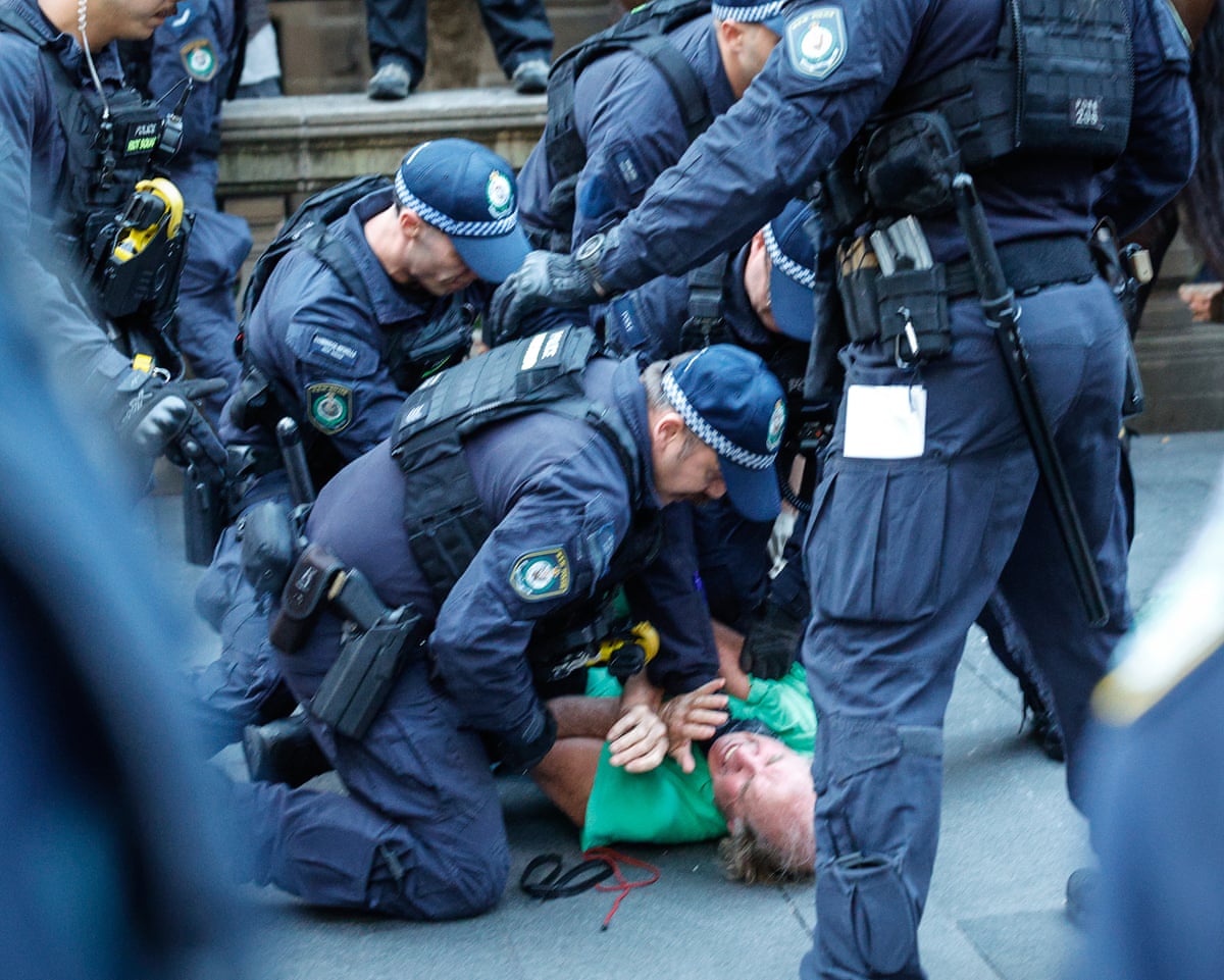 Police detaining a protester at Sydney’s Town Hall last night.