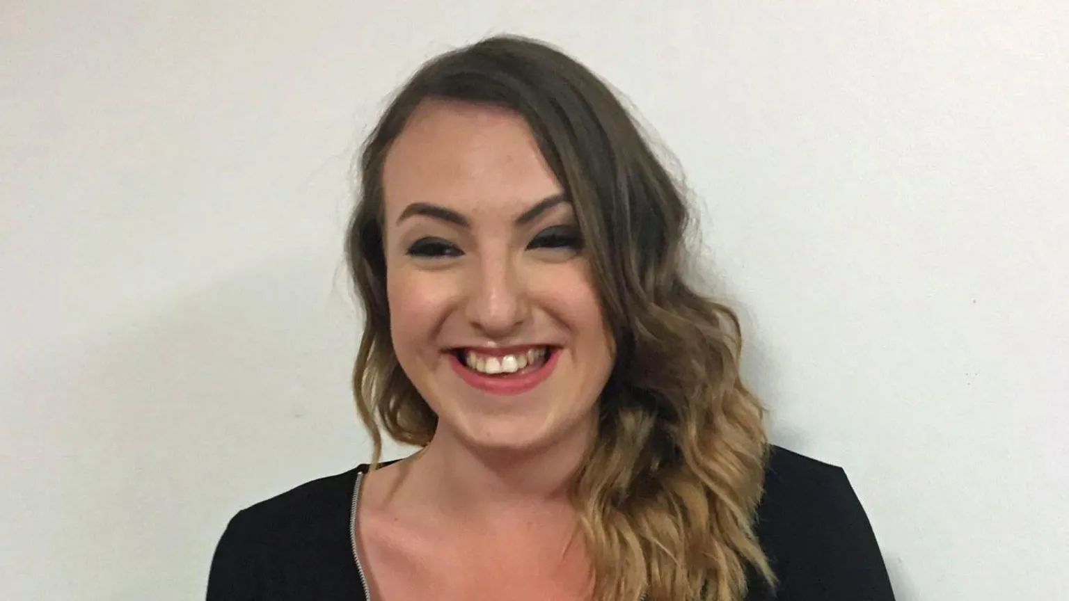 Steve James A young woman with curly brown hair smiles