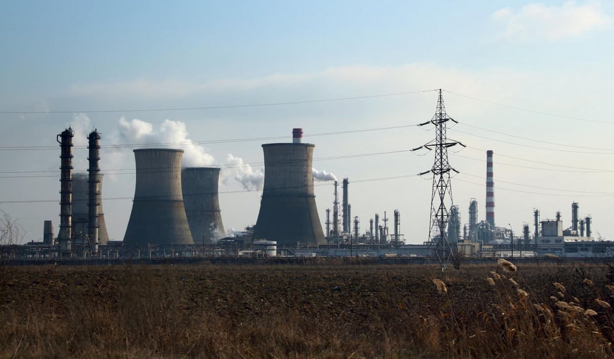 Against a blue sunny sky, white smoke plumes out of the Petrotel-Lukoil refinery in Ploiești 