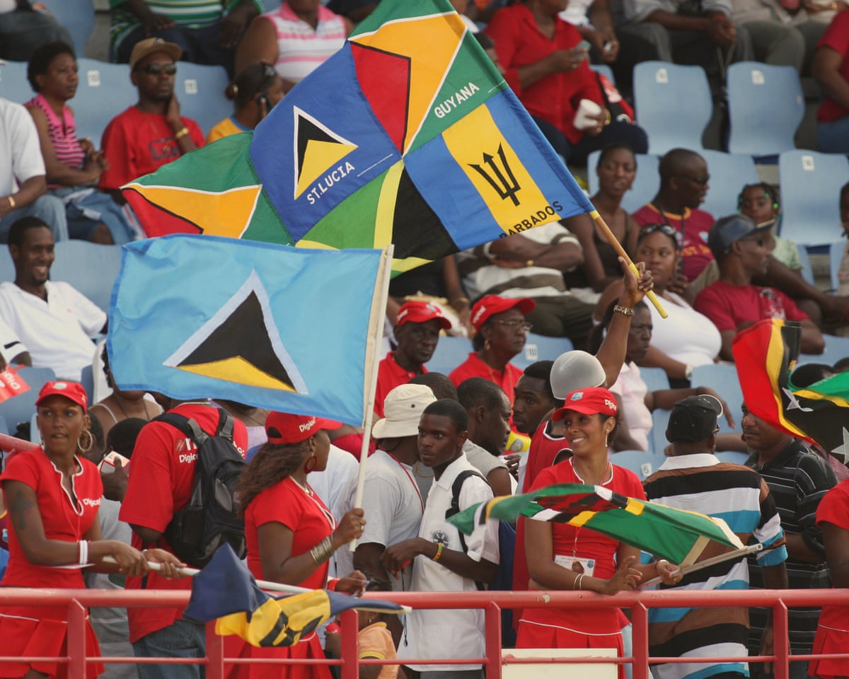Supporters of the West Indies cricket team wave flags of different Caribbean countries in a stadium’s stands