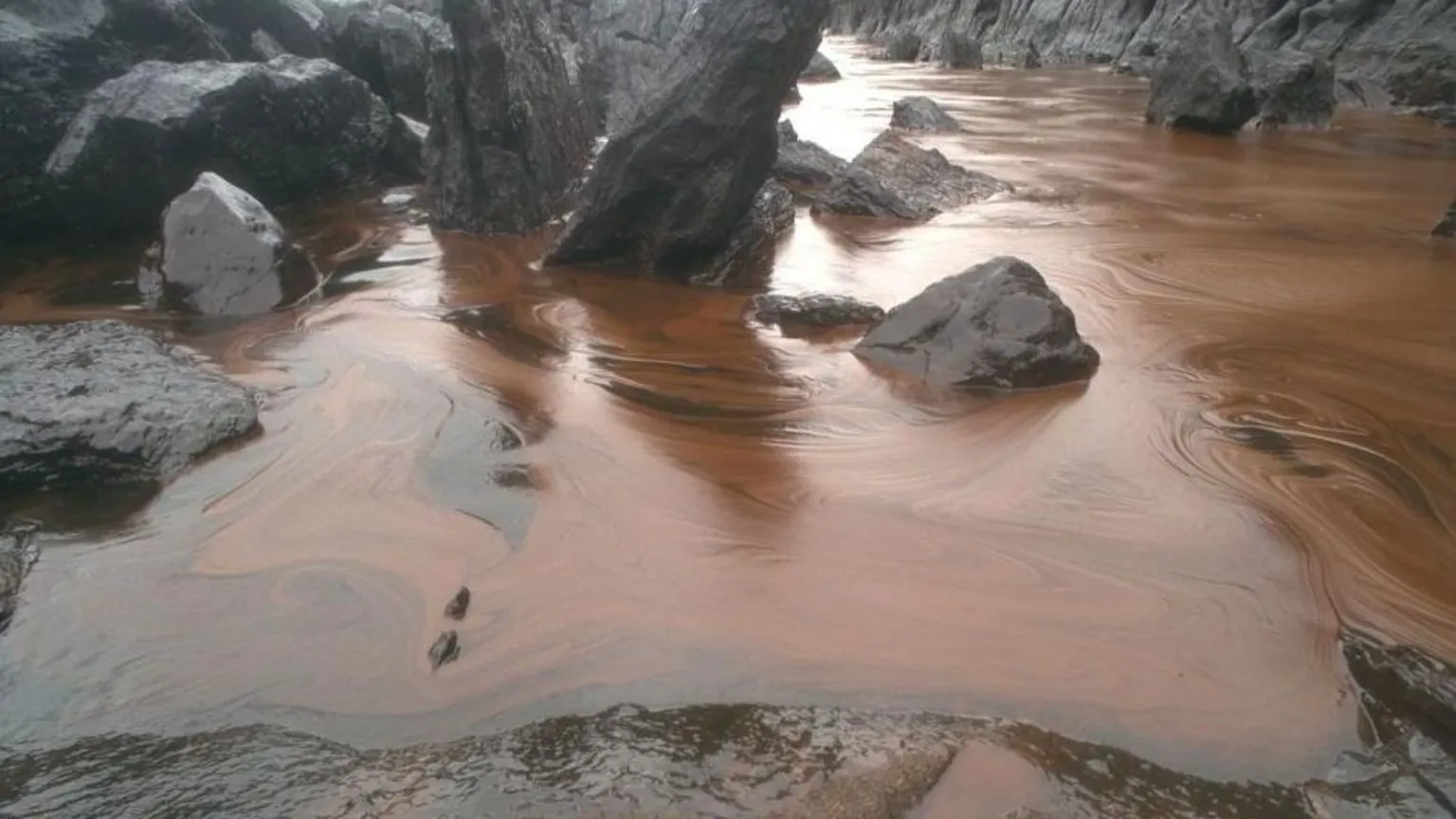  Oil coating a beach and rocks after the Sea Empress disaster in February 1996