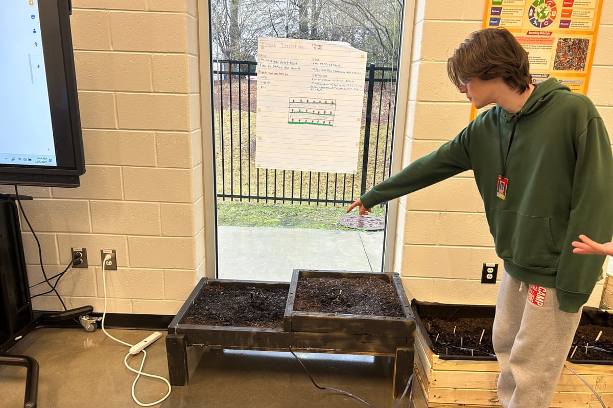 a student points at a plant bed