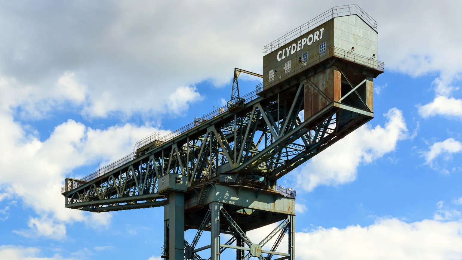  A large grey blue latticed crane with Clydeport written on the wheelhouse