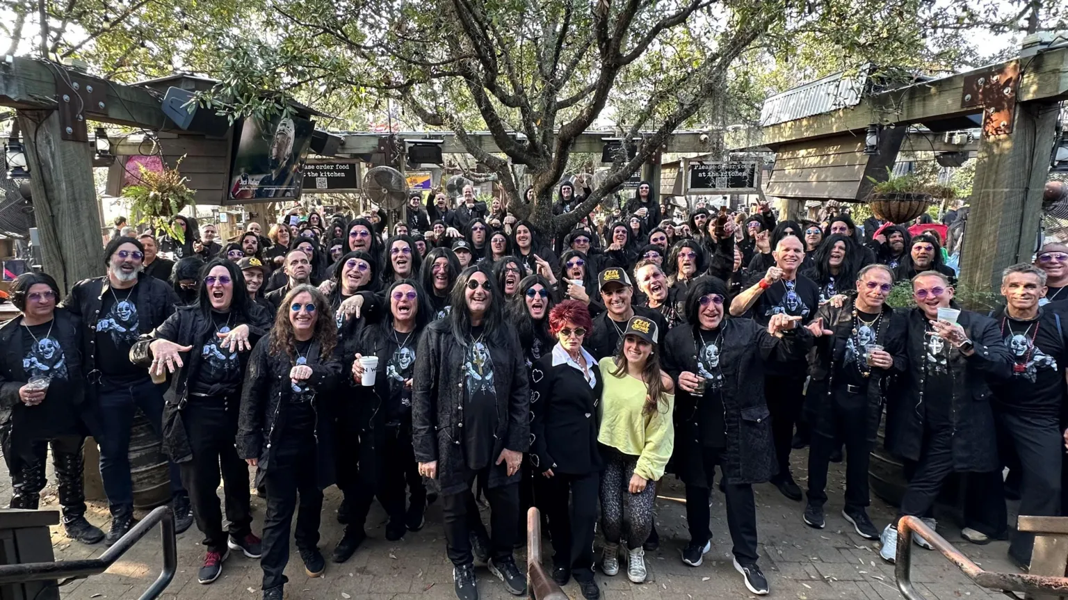 Stephen Rea A large crowd of people with most dressed as Ozzy Osbourne. Those dressed as Ozzy Osbourne are wearing black jackets, black trousers, wigs and T-shirts with Ozzy Osbourne's face on. 