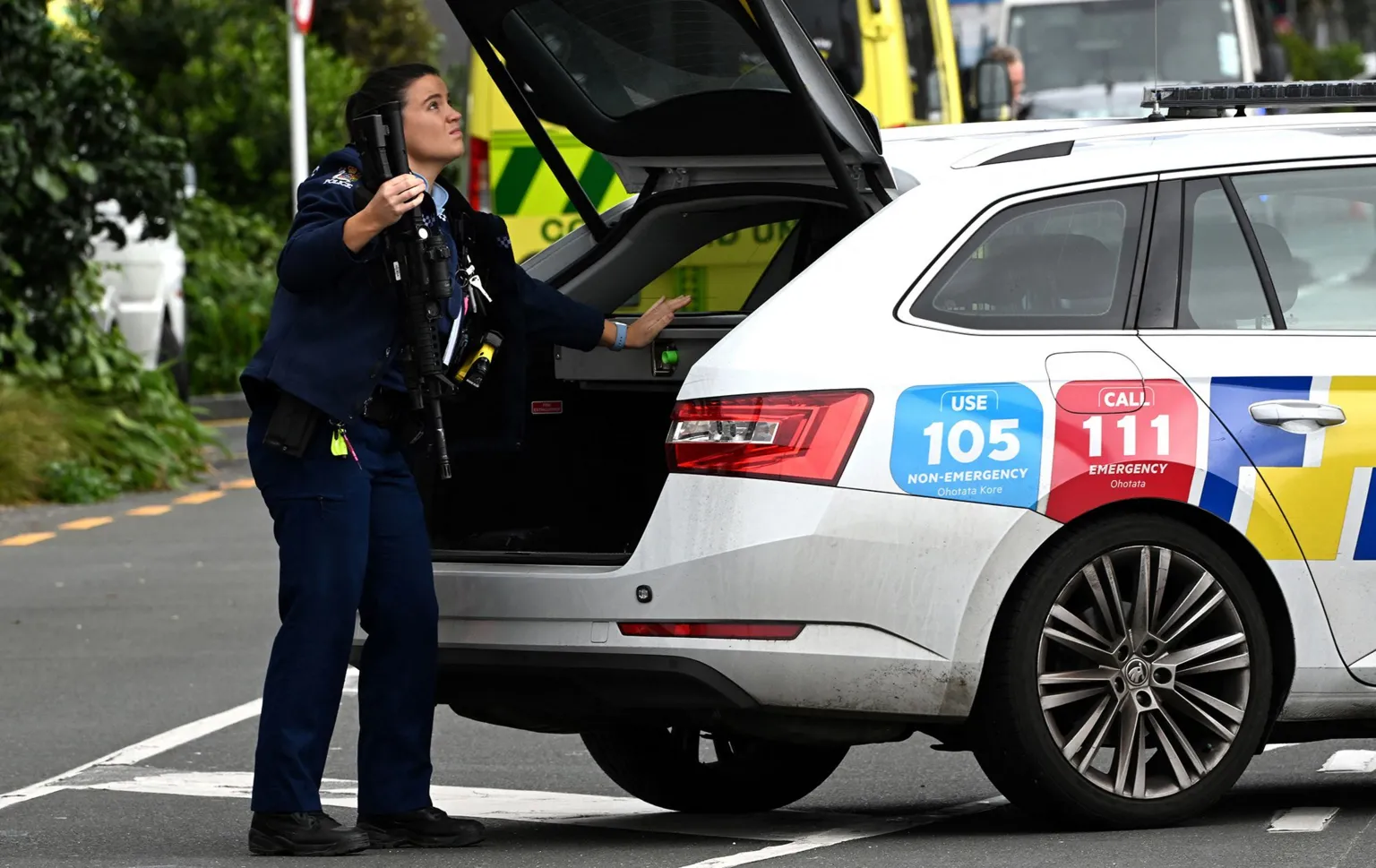 AFP via A police officer holding a gun which has been taken from a locked box in the boot of a police car