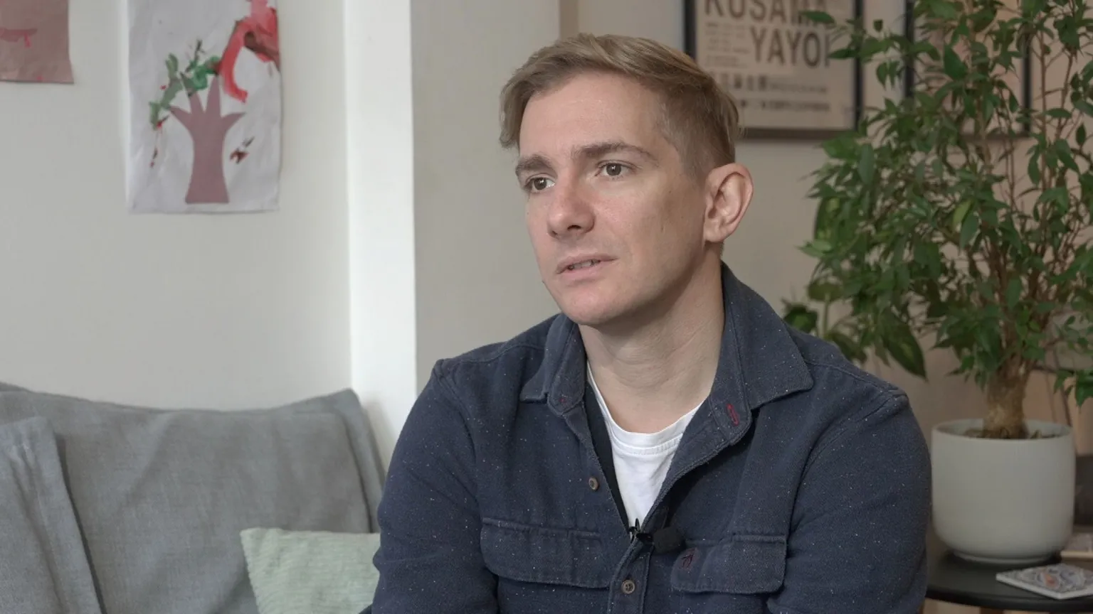 A man in a blue shirt sat in a living room