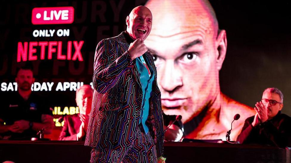 Tyson Fury pumps his first as he makes his way to the stage