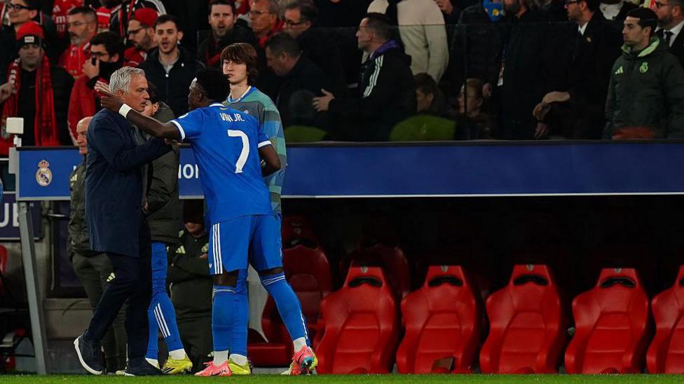 Real Madrid's Vinicius Junior speaks with Benfica manager Jose Mourinho