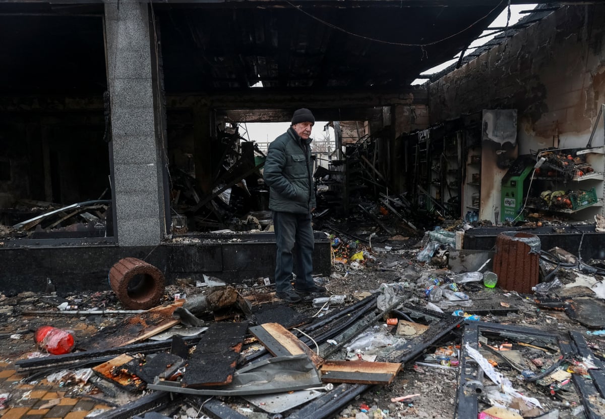 A man stood in the middle of rubble inside a wrecked building.