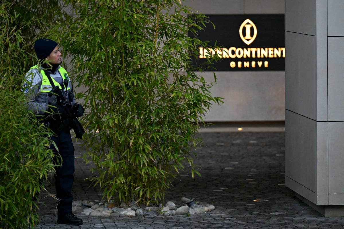 A police officer stands guard at hotel entrance.