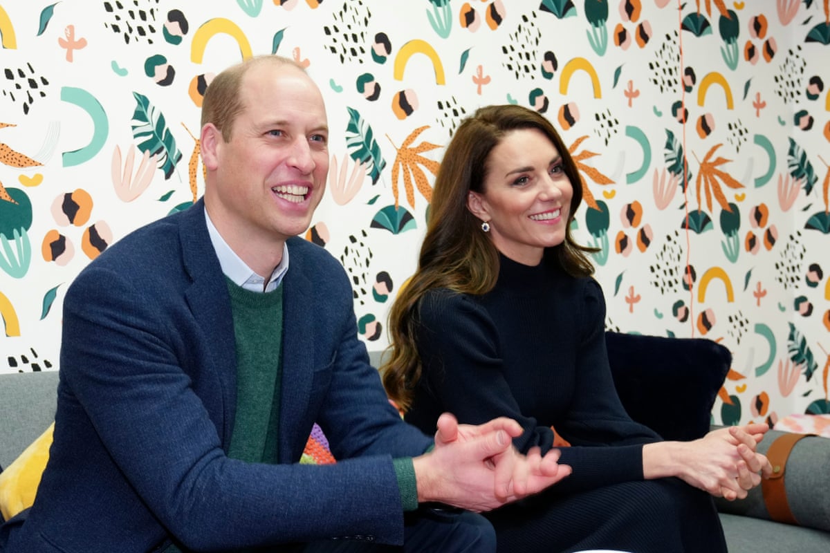 William and Catherine sitting on a sofa together talking to others