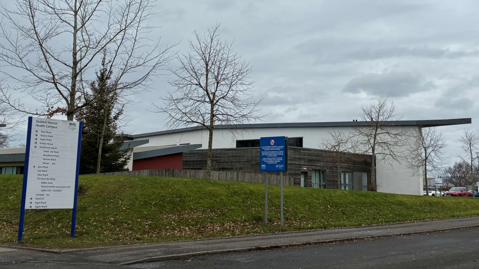 A grey and white hospital building on an overcast grey day