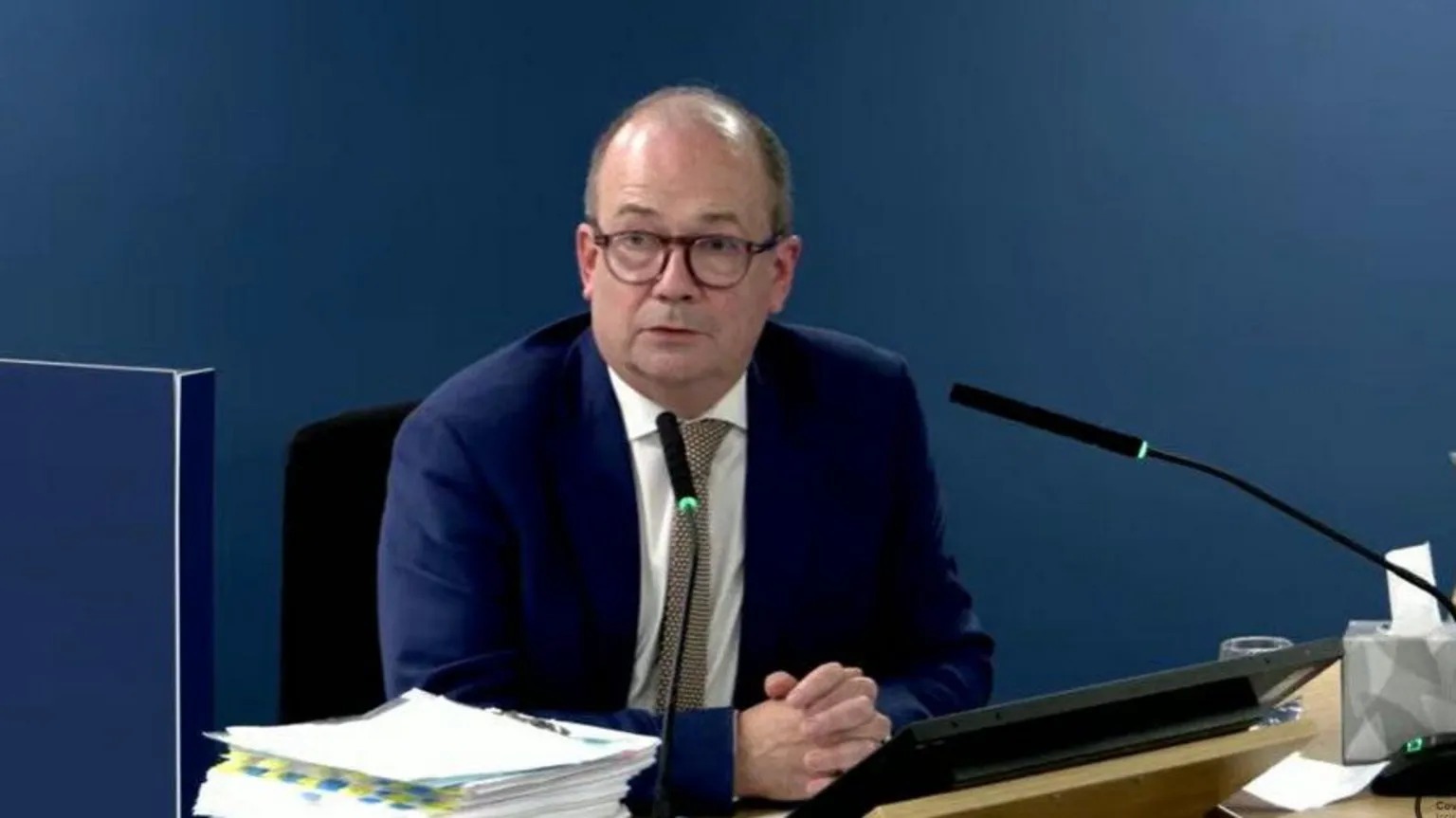  Screen grab from the UK Covid-19 Inquiry live stream of Northern Ireland chief medical officer Sir Michael McBride - he has dark hair and glasses and is wearing a navy suit, white shirt and gold and black tie.