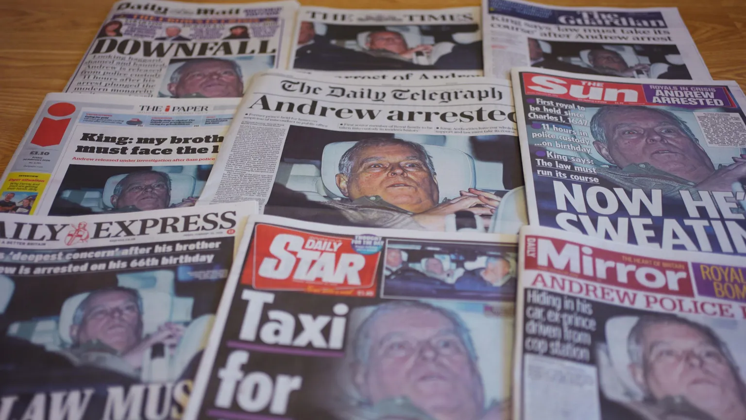  Nine of the major UK newspapers laid out on a table showing the same image of Andrew leaning back on his car seat, looking stunned.
