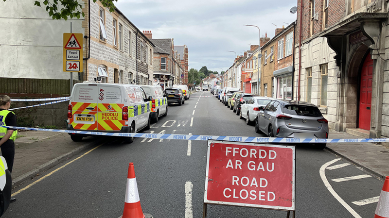 Llun o'r stryd lle cafodd Kamran Aman ei lofruddio. Mae tap yr heddlu yn nadu ceir a cherddwyr wrth i'w hymchwiliad fforensic gael ei gynnal.