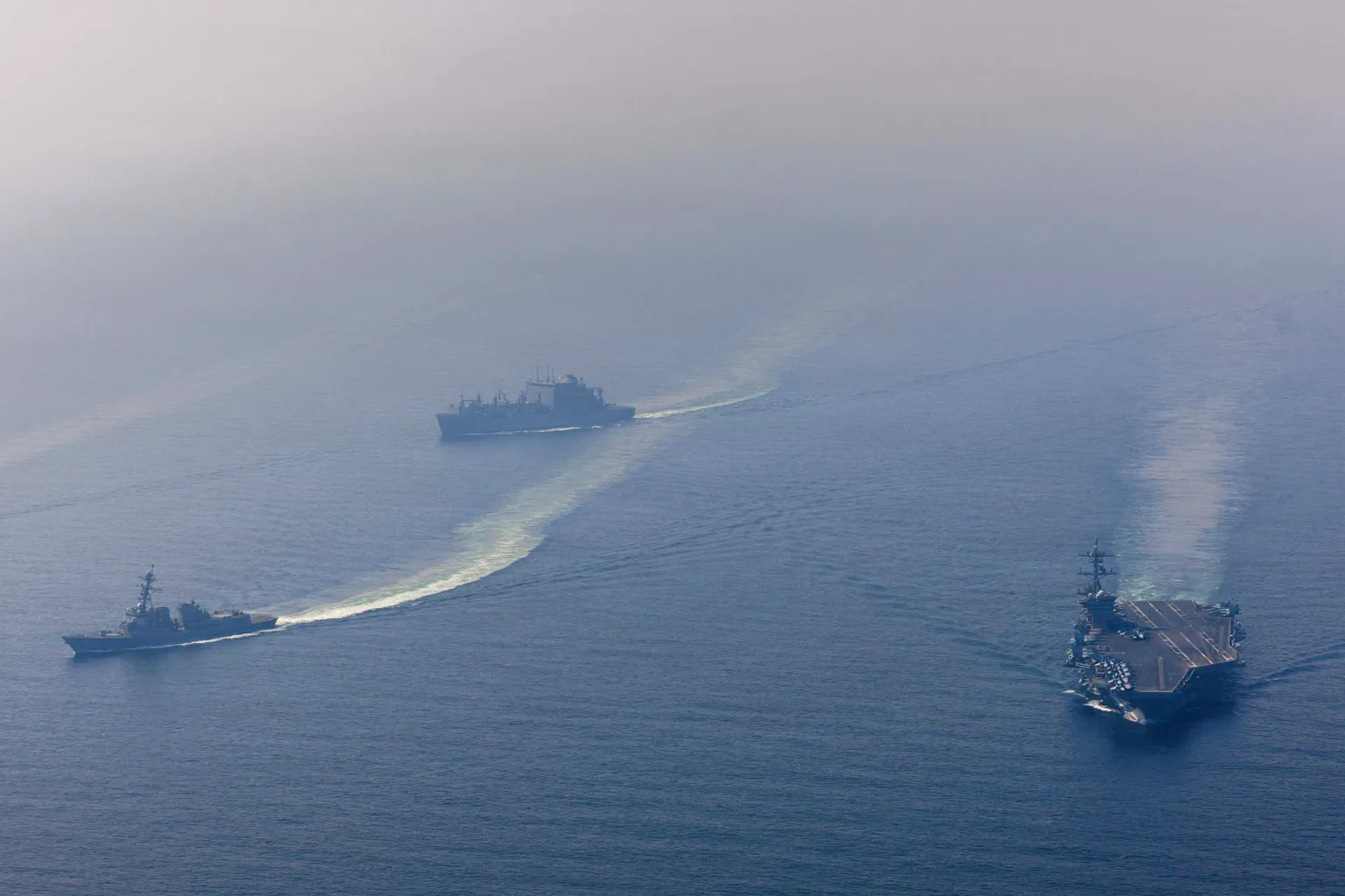  The U.S. Navy's Nimitz-class aircraft carrier USS Abraham Lincoln, Arleigh Burke-class guided-missile destroyer USS Frank E. Petersen Jr. and Lewis and Clark-class dry cargo ship USNS Carl Brashear sail during a photo exercise in the Arabian Sea, February 6, 2026. 