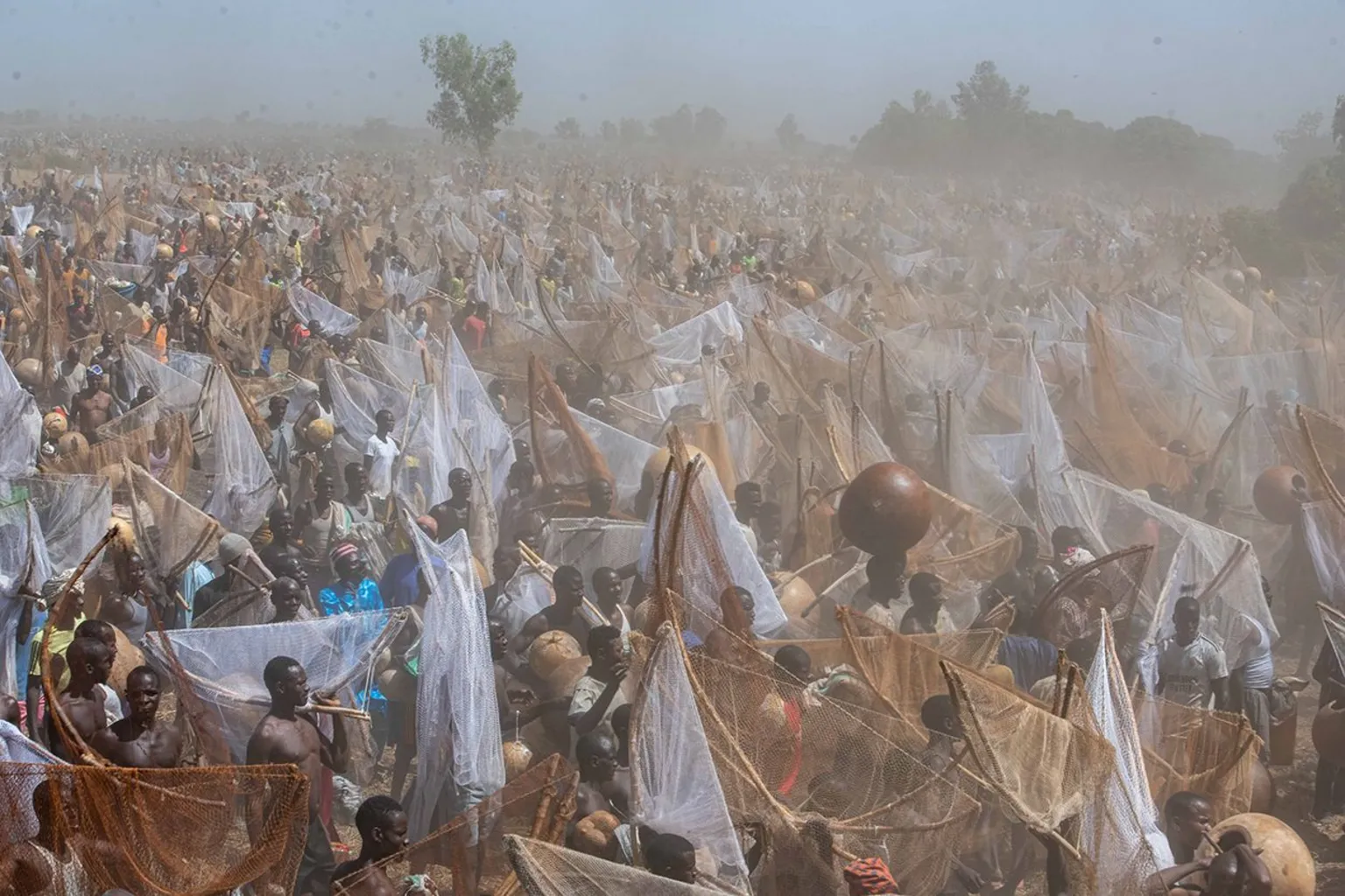 Sani Maikatanga Dust partially obscures a scene of hundreds of fishermen waiting to take part in the competition